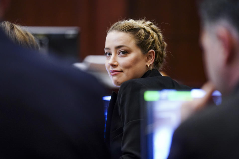 Actress Amber Heard looks over he shoulder in the courtroom at the Fairfax County Circuit Courthouse in Fairfax, Va., Thursday, April 14, 2022. Actor Johnny Depp sued his ex-wife Amber Heard for libel in Fairfax County Circuit Court after she wrote an op-ed piece in The Washington Post in 2018 referring to herself as a “public figure representing domestic abuse.” (Shawn Thew/Pool Photo via AP)
