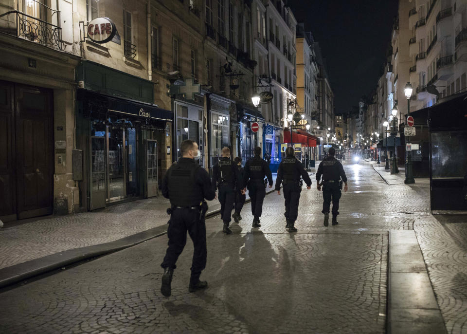 Police patrol in the streets as the curfew starts in Paris, Saturday, Oct. 17, 2020. French restaurants, cinemas and theaters are trying to figure out how to survive a new curfew aimed at stemming the flow of record new coronavirus infections. The monthlong curfew came into effect Friday at midnight, and France is deploying 12,000 extra police to enforce it. (AP Photo/Lewis Joly)