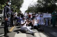 Respiratory Hospital INERAM health workers block the street outside their hospital to demand more materials for the ICU in Asuncion, Paraguay, Wednesday, March 3, 2021, the day after INERAM Director Felipe Gonzalez resigned. Without vaccines or basic drugs to combat COVID-19, Paraguay's main public hospitals became unable to receive patients in intensive care units on Wednesday. (AP Photo/Jorge Saenz)