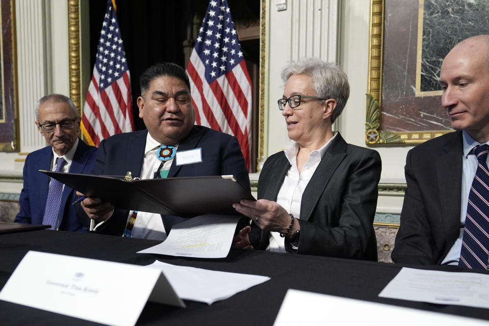 Chair Shannon Wheeler of the Nez Perce Tribe, second from left, passes a document to Oregon Gov. Tina Kotek, second from right, during a signing ceremony in Washington, Friday, Feb. 23, 2024, as White House senior adviser and climate envoy John Podesta, left, and Deputy Secretary of Energy David Turk, right, watch. The ceremonial signing is an agreement between the Biden administration and state and Tribal governments to work together to protect salmon and other native fish, honor obligations to Tribal nations, and recognize the important services the Columbia River System provides to the economy of the Pacific Northwest. (AP Photo/Susan Walsh)