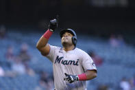 Miami Marlins' Jesus Aguilar points to the sky as he arrives at home plate after hitting a two-run home run against the Arizona Diamondbacks during the first inning of a baseball game Wednesday, May 12, 2021, in Phoenix. (AP Photo/Ross D. Franklin)