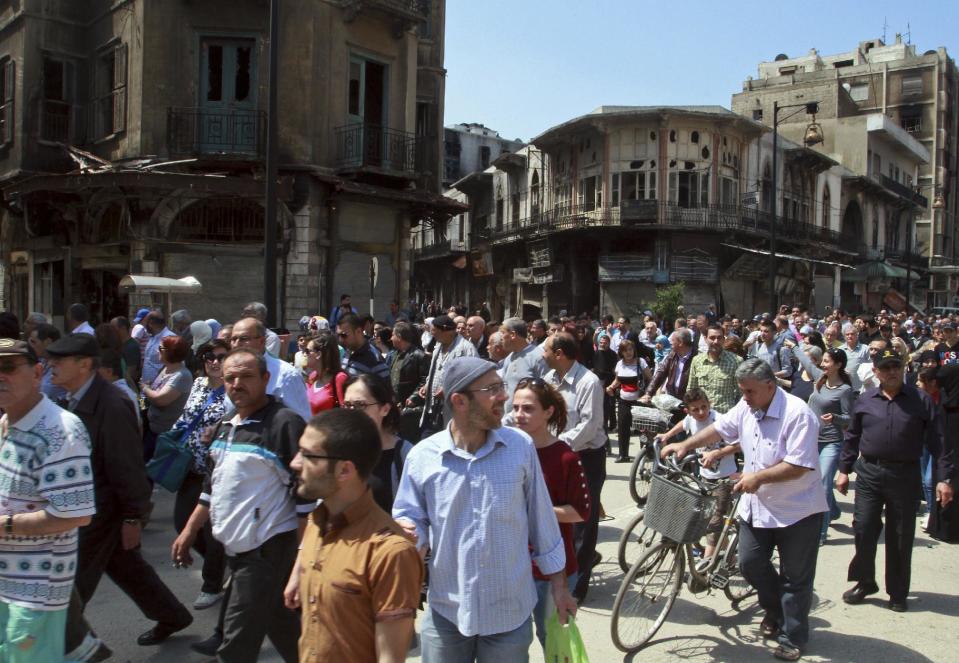 Residents return to the al-Hamidiyeh neighborhood of Homs, Syria, Saturday, May 10, 2014. Thousands of Syrians streamed into war-battered parts of the central city of Homs for the first time in nearly two years Saturday, many making plans to move back just days after rebels surrendered their strongholds to pro-government forces. The surrender deal is widely seen as a victory for Assad weeks ahead of a presidential election on June 3 that he is expected to win, giving him a mandate to continue his violent crackdown on rebels in the Syrian civil war, which activists say has killed more than 150,000 people. (AP Photo)