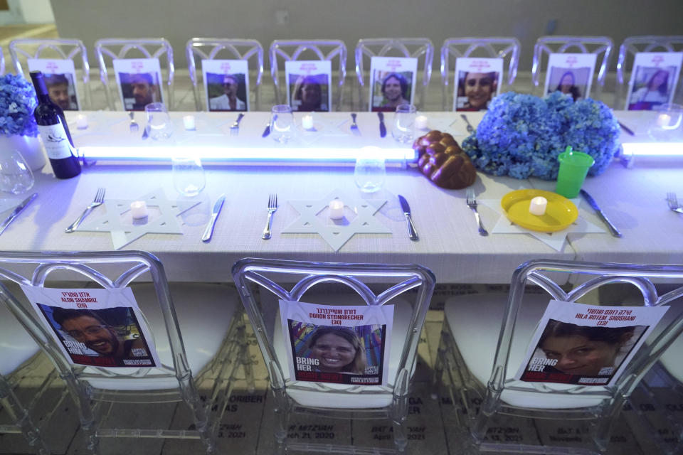 A table with photographs of those who have been kidnapped by Hamas in Israel, during an empty Shabbat table event, Thursday, Nov. 2, 2023, at Temple Beth Sholom in Miami Beach, Fla. The holiday of Hanukkah, Judaism's festival of lights, will be both more needed and more poignant than ever this year, say Jews from across the religious observance and political spectrum in Miami Beach and neighboring South Florida communities. (AP Photo/Wilfredo Lee)