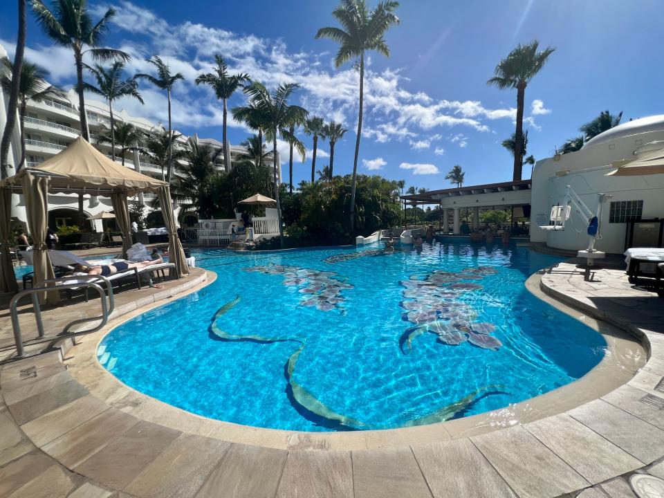 pool in hawaii surrounded by palm trees