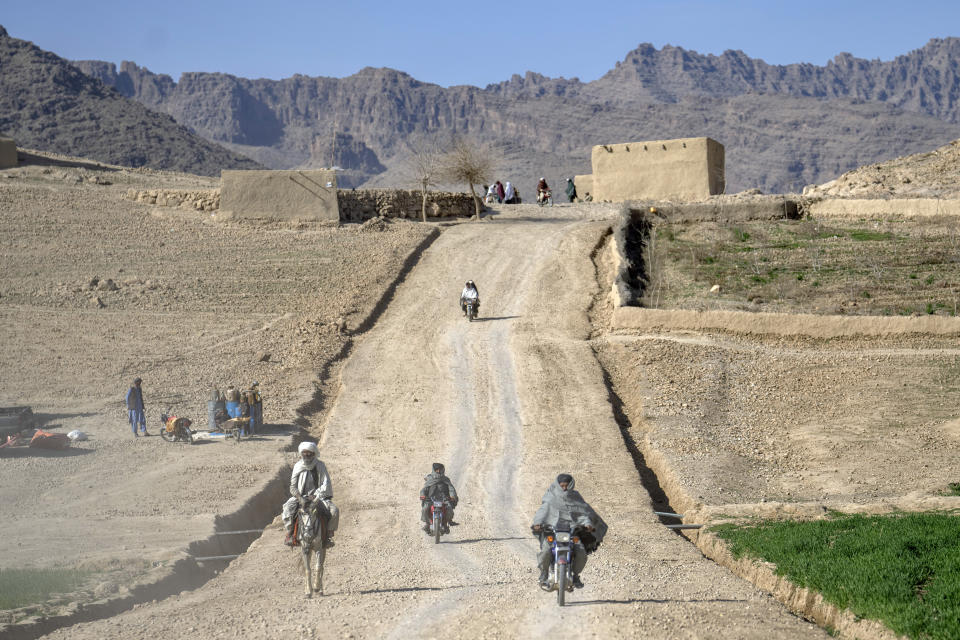 People travel along a dirt road in a village in a remote region of Afghanistan, on Friday, Feb. 24, 2023. (AP Photo/Ebrahim Noroozi)