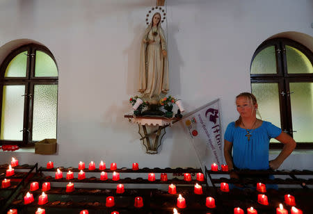Candles lit in front of a statue of the Virgin Mary in the chapel in Csatka, Hungary on September 9, 2017. REUTERS/Laszlo Balogh