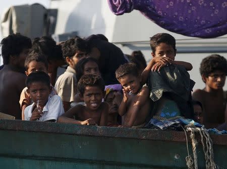 Migrants are seen aboard a boat tethered to a Thai navy vessel, in waters near Koh Lipe island, May 16, 2015. REUTERS/Olivia Harris