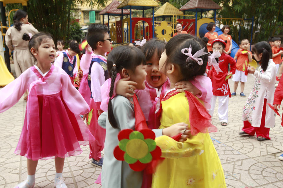 In this Thursday, Feb. 21, 2019, photo, children in Vietnamese and Korean traditional costumes hug at each other at Vietnam-Korea Friendship Kindergarten in Hanoi, Vietnam. The children have been practicing singing and dancing, hoping to show off their talents to North Korean leader Kim Jong Un when he comes to town this week for his second summit meeting with U.S. President Donald Trump. (AP Photo/Hau Dinh)