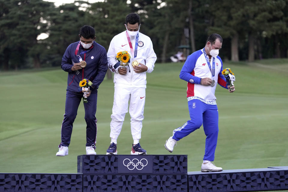 Xander Schauffele, of the United States, holds his gold medal next to bronze medal winner C.T. Pan of Taiwan, left, and silver medal winner Rory Sabbatini, of Slovakia, right, for the men's golf at the 2020 Summer Olympics on Sunday, Aug. 1, 2021, in Kawagoe, Japan. (AP Photo/Andy Wong)