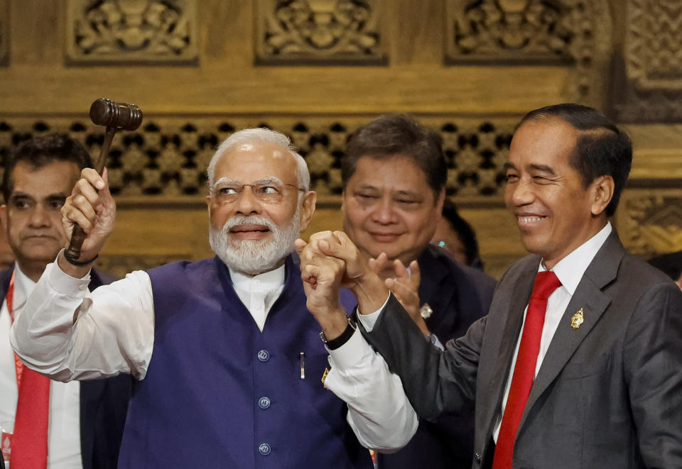 India's Prime Minister Narendra Modi, left, holds the gavel besides Indonesia's President Joko Widodo during the handover ceremony at the G20 Leaders' Summit, in Nusa Dua, Bali, Indonesia, Wednesday, Nov. 16, 2022. (Willy Kurniawan/Pool Photo via AP)
