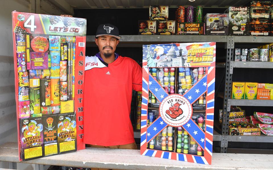 Fireworks stand operator Jessie Fierro III shows large multipacks of fireworks for adults in this July 27, 2022, file photo. Fire works sales begin Monday.