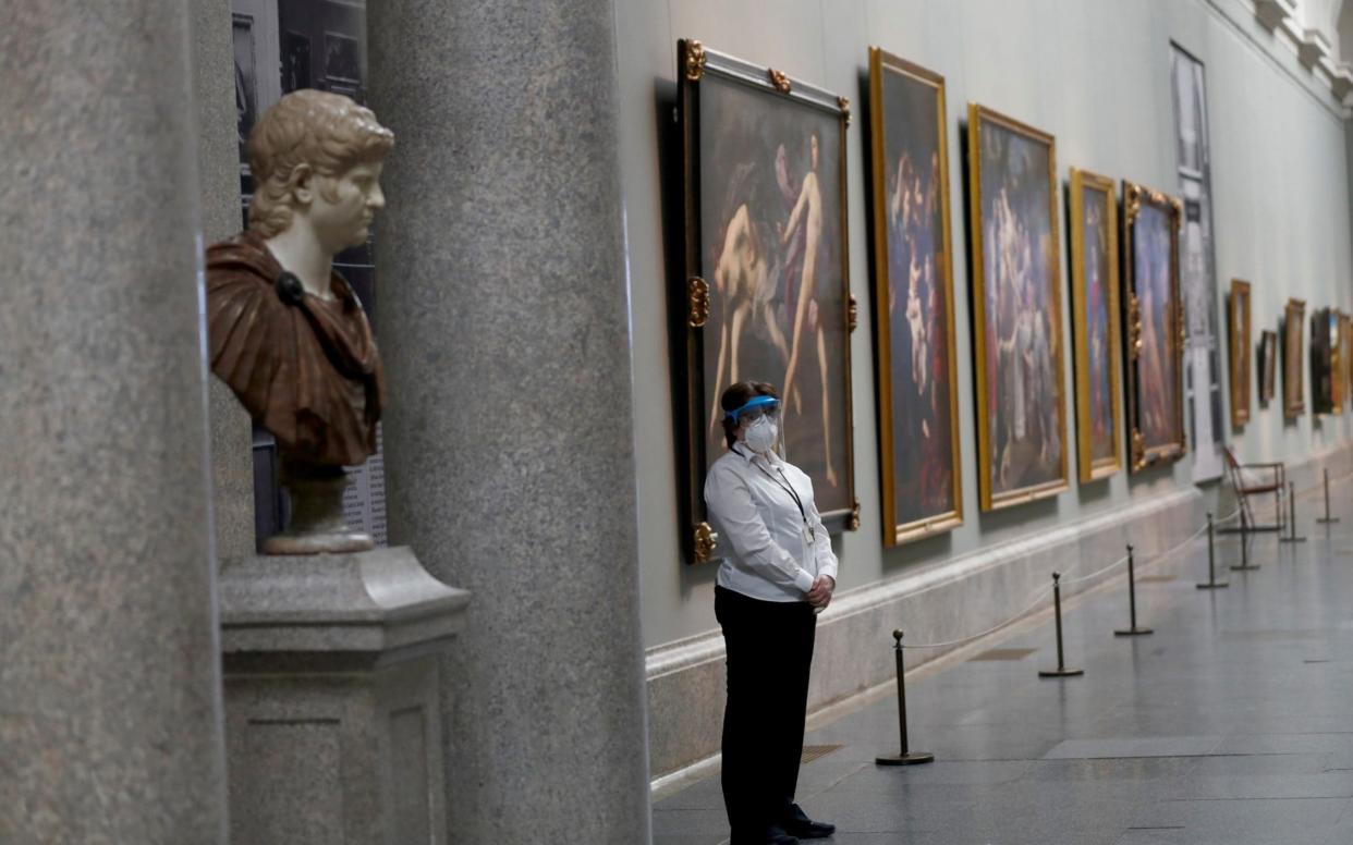 A museum worker wears a protective mask as the Prado museum prepares for reopening - Reuters