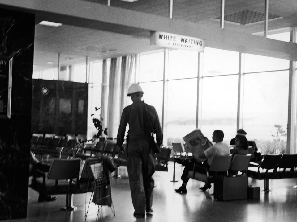 People sit in the "White Waiting" area inside an office building, Alabama, circa 1960.