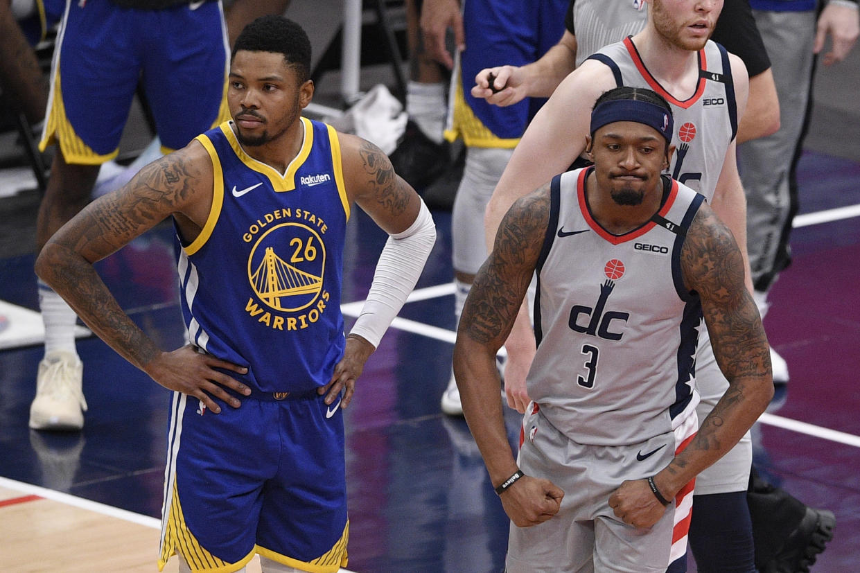 Washington Wizards guard Bradley Beal (3) reacts next to Golden State Warriors forward Kent Bazemore (26) during the second half of an NBA basketball game, Wednesday, April 21, 2021, in Washington. The Wizards won 118-114. (AP Photo/Nick Wass)