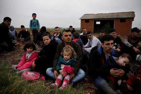 Syrian refugees who crossed the Evros river, the natural border between Greece and Turkey, rest on a field as they wait for the police to arrive and transfer them to a first reception centre, near the village of Nea Vyssa, Greece, May 2, 2018. REUTERS/Alkis Konstantinidis