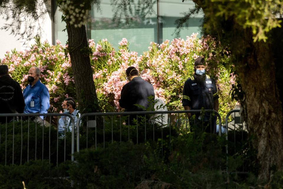 Santa Clara Valley Transportation Authority (VTA) workers gather near a railyard following a shooting on Wednesday, May 26, 2021, in San Jose, Calif. Santa Clara County sheriff's spokesman said the railyard shooting left multiple people, including the shooter, dead. 