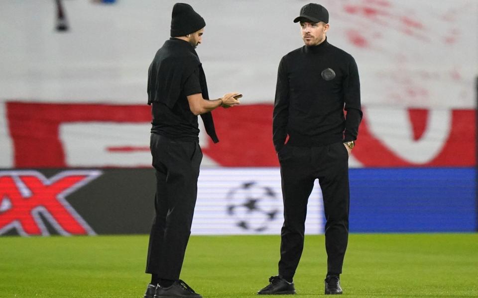 Manchester City's Jack Grealish (right) and Riyad Mahrez on the pitch before the Champions League round of 16 - PA/Tim Goode