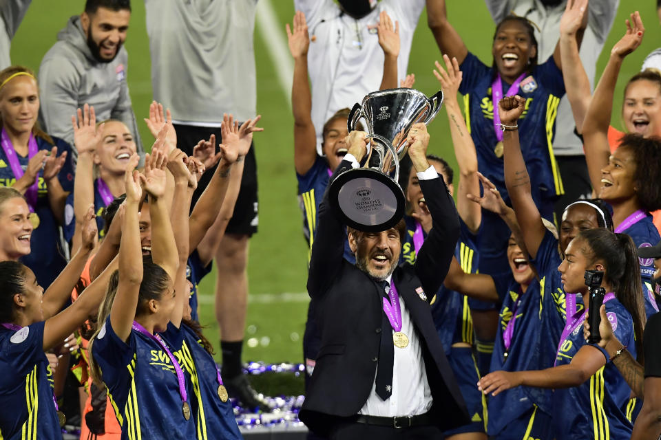 Lyon's coach Jean Luc Vasseur lifts the trophy after winning the Women's Champions League final soccer match between Wolfsburg and Lyon at the Anoeta stadium in San Sebastian, Spain, Sunday, Aug. 30, 2020. Lyon won 3-1.(AP PhotoAlvaro Barrientos, Pool)