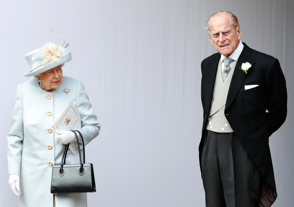 TOPSHOT - Britain's Queen Elizabeth II (L) and Britain's Prince Philip, Duke of Edinburgh (R) wait for the carriage carrying Princess Eugenie of York and her husband Jack Brooksbank to pass at the start of the procession after their wedding ceremony at St George's Chapel, Windsor Castle, in Windsor, on October 12, 2018. (Photo by Alastair Grant / POOL / AFP)        (Photo credit should read ALASTAIR GRANT/AFP via Getty Images)