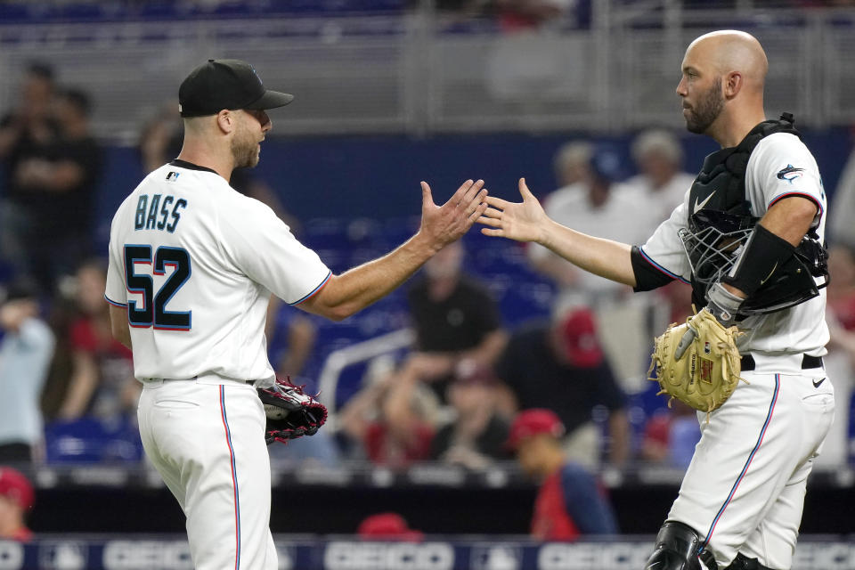 Miami Marlins relief pitcher Anthony Bass (52) shakes hands with catcher Jacob Stallings after a baseball game against the St. Louis Cardinals, Thursday, April 21, 2022, in Miami. (AP Photo/Lynne Sladky)