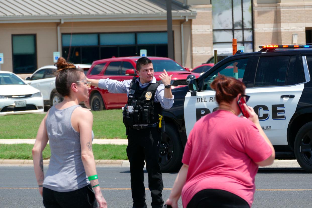 A law enforcement officer helps people cross the street at Uvalde Memorial Hospital after a shooting was reported earlier in the day at Robb Elementary School, Tuesday, May 24, 2022, in Uvalde, Texas. 