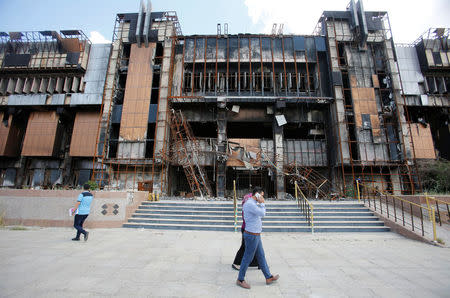 Iraqi students walk near a building of the central Library of the University of Mosul, in Mosul, Iraq May 14, 2018. Picture taken May 14, 2018. REUTERS/Khalid Al-Mousily