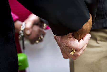 Marchers hold hands after a prosecutor said that a police officer will not face charges in the fatal shooting of an unarmed 19-year-old biracial man, in Madison, Wisconsin May 12, 2015. REUTERS/Ben Brewer