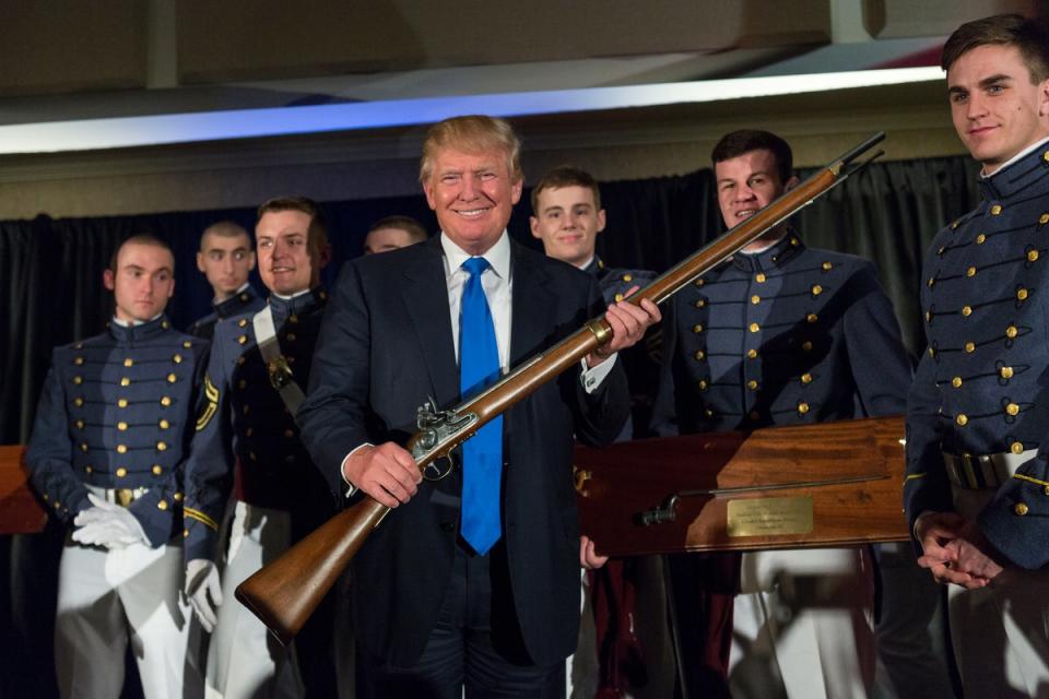 Donald Trump holds up a replica flintlock rifle awarded him by cadets during the Republican Society Patriot Dinner at the Citadel Military College on February 22, 2015 in Charleston, South Carolina. NYPD officials are set to revoke his gun licenese following his felony conviction. (Getty Images)
