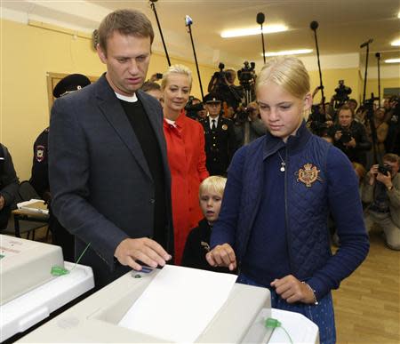 Russian opposition leader Alexei Navalny (L), accompanied by his wife Yulia (2nd L) and children Dasha and Zakhar (2nd L), casts his vote at a polling station in Moscow September 8, 2013. REUTERS/Sergei Karpukhin
