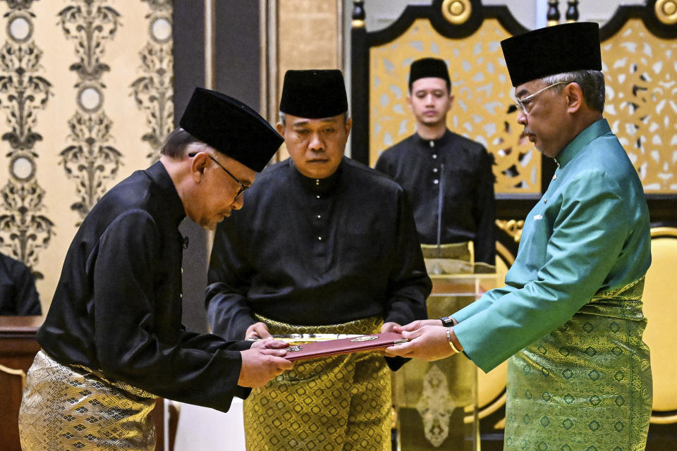 Malaysia's King Sultan Abdullah Sultan Ahmad Shah, right, and newly appointed Prime Minister Anwar Ibrahim, left, take part in the swearing-in ceremony at the National Palace in Kuala Lumpur, Malaysia, Thursday, Nov. 24, 2022. Malaysia's king on Thursday named Anwar as the country's prime minister, ending days of uncertainty after the divisive general election produced a hung Parliament. (Mohd Rasfan/Pool Photo via AP)