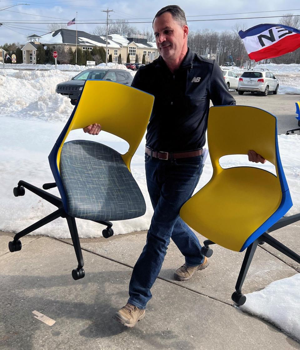 KI Plant Manager Stuart Kolb brings in two of the 12 new chairs, in the colors of the Ukrainian flag, that the company donated Friday, March 3, 2023, to Door County Candle Company in Sturgeon Bay.