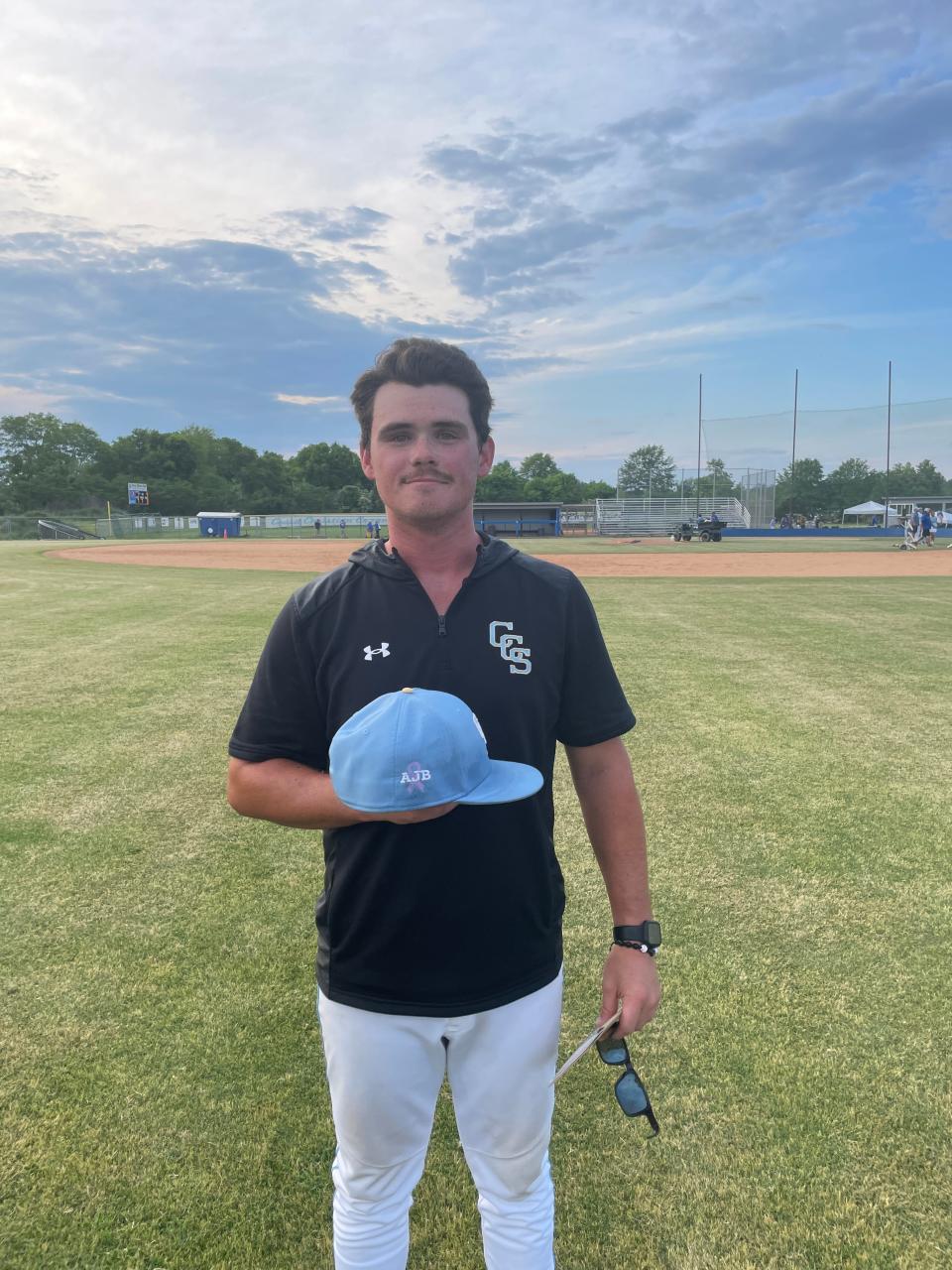 Coosa Christian baseball assistant coach Logan Brooks poses with the hat bearing his mother's initials after a Class 1A quarterfinal win on Thursday, May 2, 2024. (Maxwell Donaldson, The Gadsden Times)