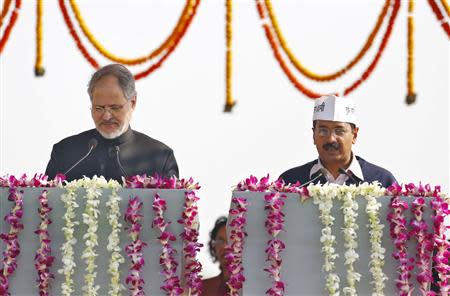 Najeeb Jung (L), Delhi's Lieutenant Governor, administers the oath to Arvind Kejriwal, leader of Aam Aadmi (Common Man) Party (AAP), as the new chief minister of Delhi during a swearing-in ceremony at Ramlila grounds in New Delhi December 28, 2013. REUTERS/Anindito Mukherjee