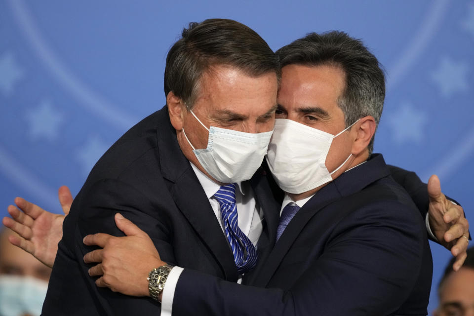 Brazil's President Jair Bolsonaro, left, embraces his new Chief of Staff Ciro Nogueira during Nogueira´s swearing-in ceremony at the Planalto presidential palace, in Brasilia, Brazil, Wednesday, Aug. 4, 2021. (AP Photo/Eraldo Peres)