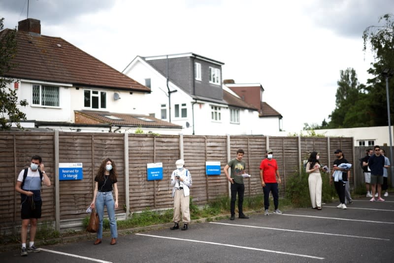 People queue outside a vaccination centre for those aged over 18 at the Belmont Health Centre in Harrow, amid the coronavirus disease (COVID-19) outbreak, in London