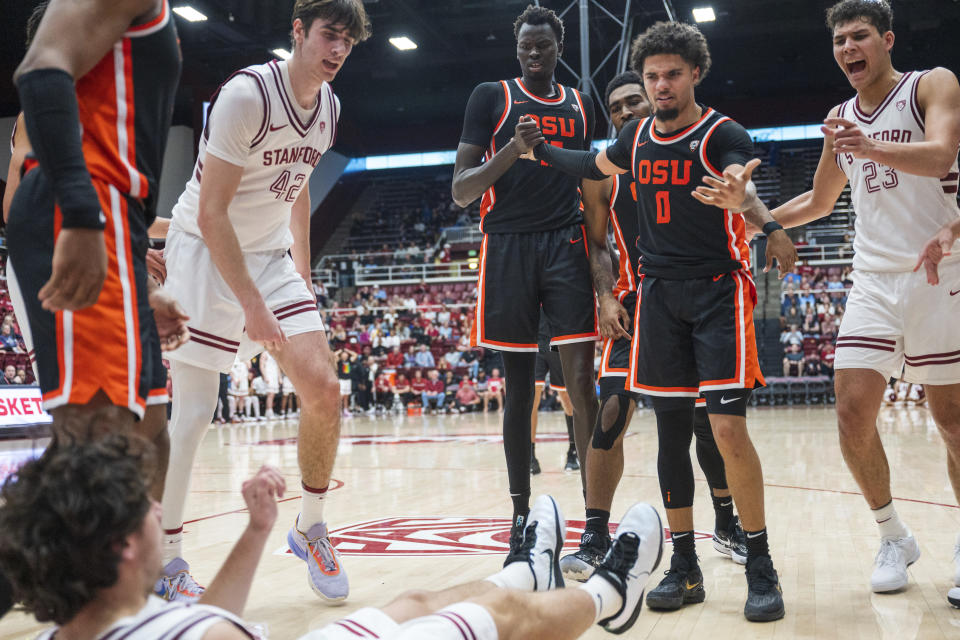 Stanford forward Maxime Raynaud (42) and forward Brandon Angel (23) look at Stanford guard Benny Gealer, front left, after he was pushed to the floor by Oregon State guard Jordan Pope (0) during the second half of an NCAA college basketball game Saturday, Feb. 24, 2024, in Stanford, Calif. (AP Photo/Nic Coury)