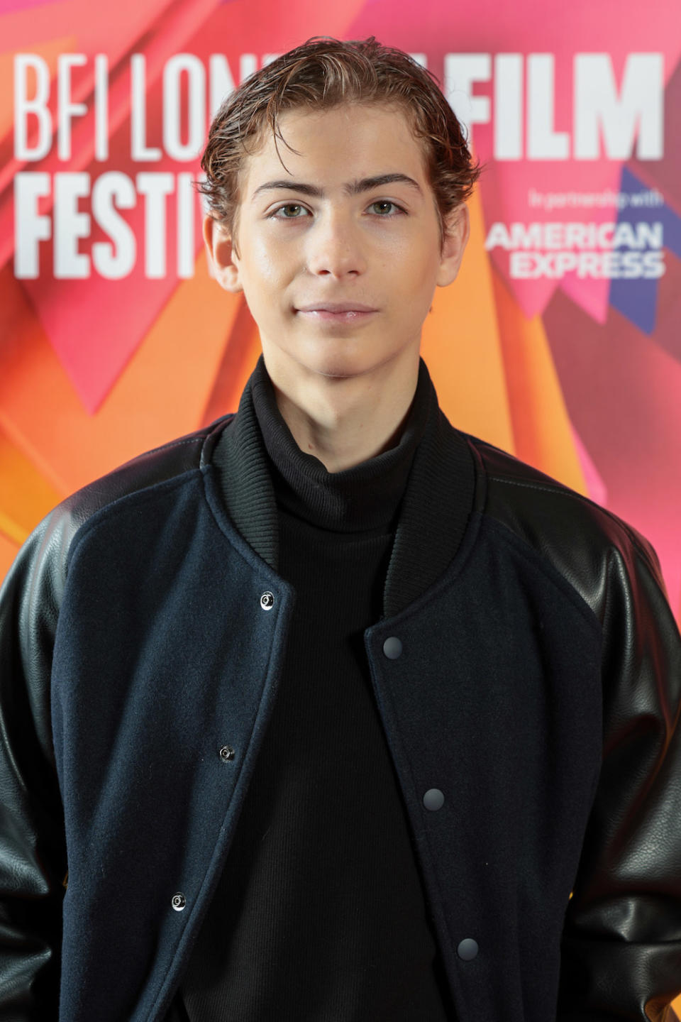 closeup of Jacob wearing a letterman style jacket with gelled back hair