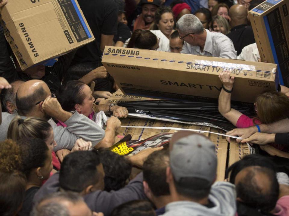 Dozens of Brazilians reach for television sets in a storeinf Sao Paulo (EPA)