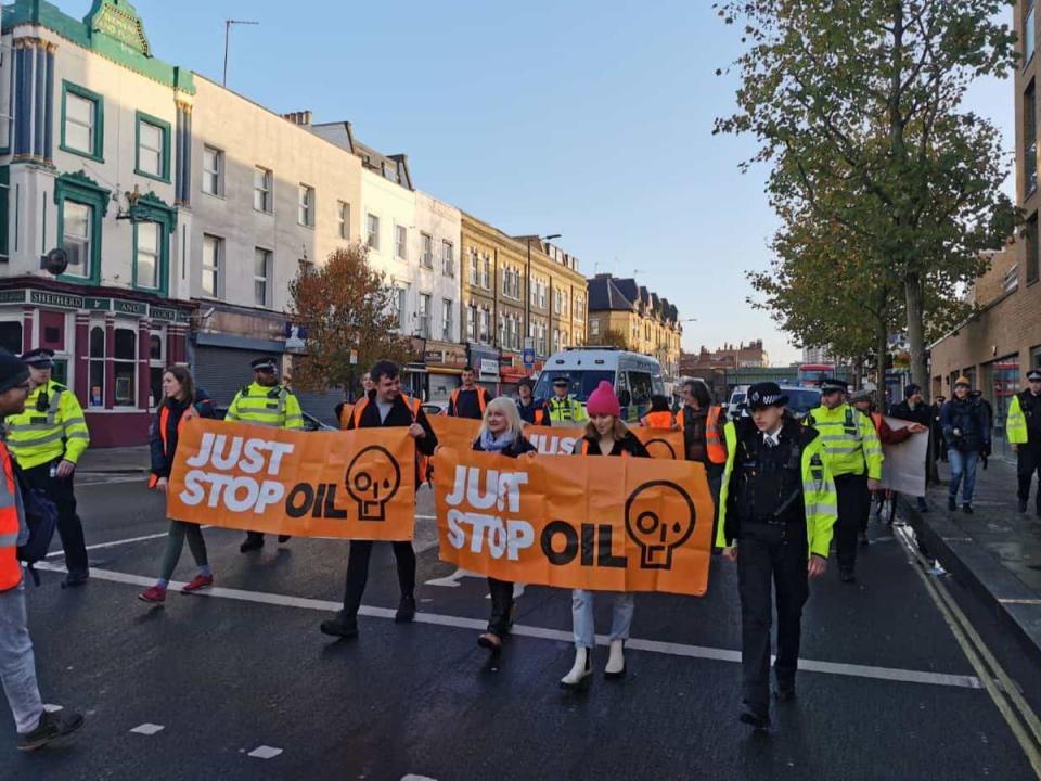 Just Stop Oil carried banners along the street in west London (Just Stop Oil)