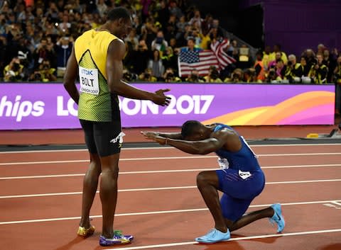 Gatlin bows down at Bolt's knees after the race - Credit: REUTERS/Dylan Martinez