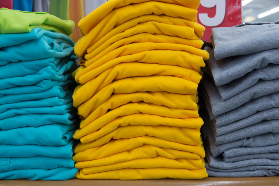 Stack of T-shirt in Department Store or Shopping Mall Retail Store Shop. Yellow, Blur and Grey Color Leisure shirt.