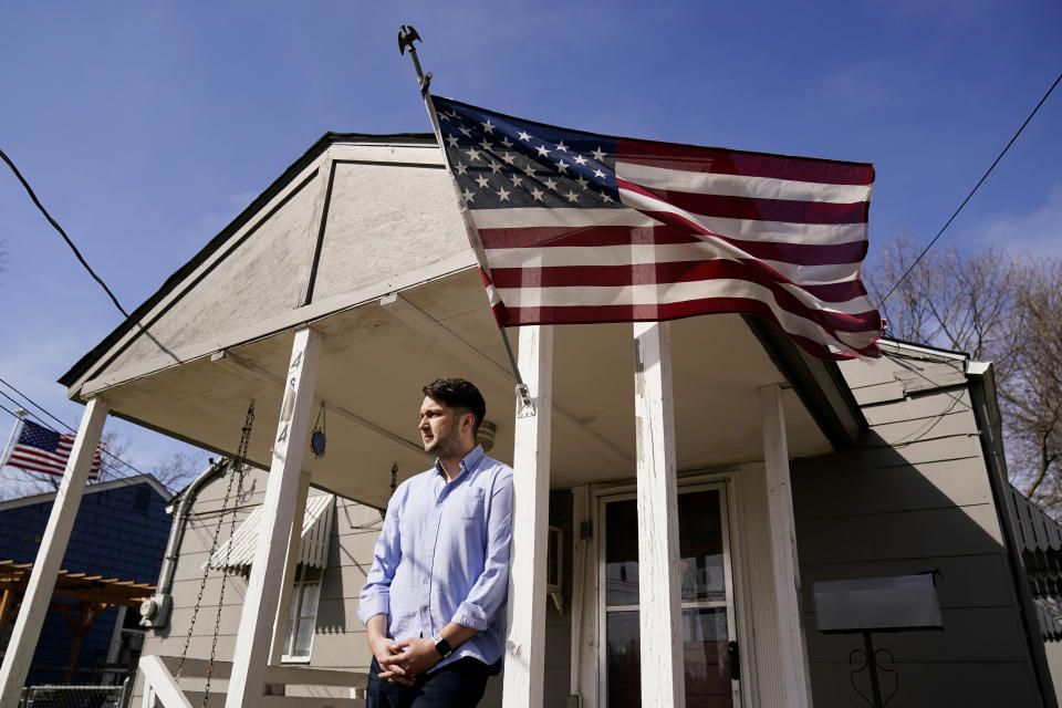 Logan DeWitt stands outside his home Monday, March 8, 2021, in Kansas City, Kan. Because he could work at home, Logan kept his job through the pandemic while his wife lost hers and went back to school. Their financial situation was further complicated with the birth of their daughter nine months ago. (AP Photo/Charlie Riedel)