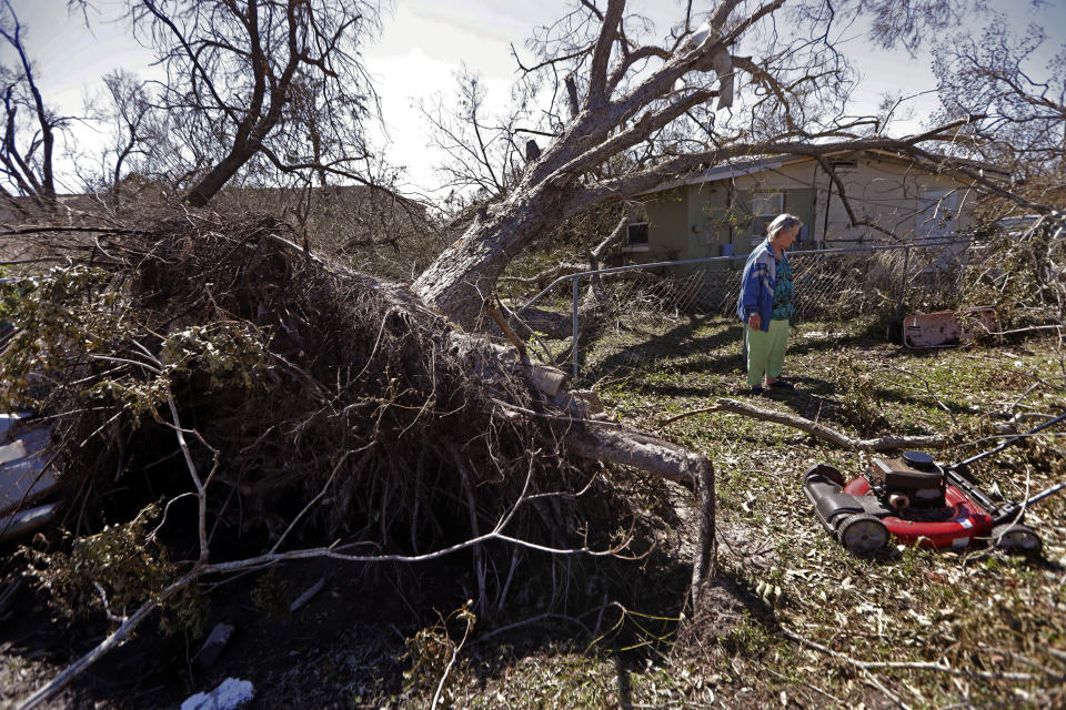 Mary Frances Parrish shows her toppled pecan tree, which fell in a neighbor's house, in the aftermath of Hurricane Michael in Panama City, Fla., Saturday, Oct. 13, 2018. Parrish didn't leave the storm because her car was broken down, she didn't have a place to go and if she did she didn't have the money for it. She is caring for her terminally ill son who lives with her. (AP Photo/Gerald Herbert)