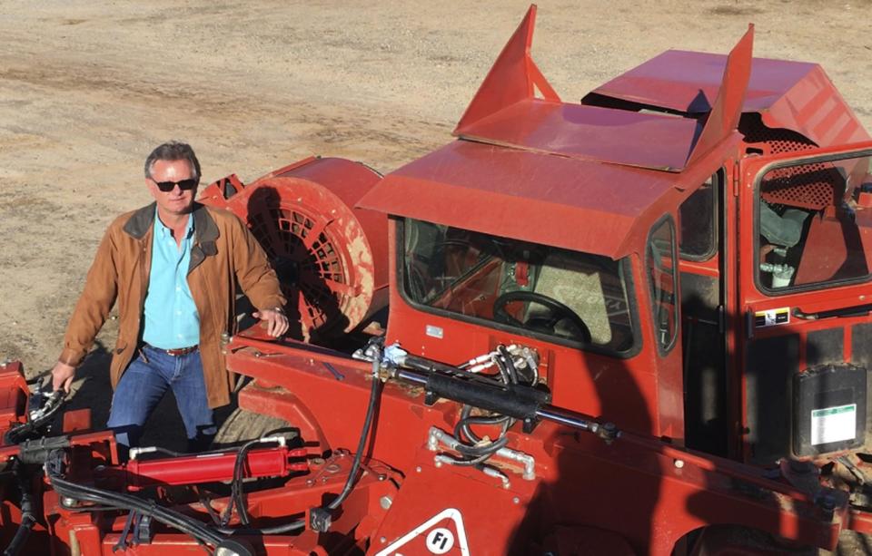 In this Dec. 27, 2016 photo, farmer Kevin Herman stands next to an almond sweeper at his ranch near Madera, Calif. Herman says that Donald Trump's campaign vow to deport millions of immigrants who are in the country illegally pushed him into buying more equipment, cutting the number of workers he'll need during the next harvest. (AP Photo/Scott Smith)