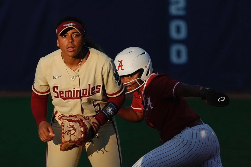 Elissa Brown of the Alabama Crimson Tide (right) runs to second as Florida State Seminoles infielder Elizabeth Mason defends during the fifth inning of the Women's College World Series.