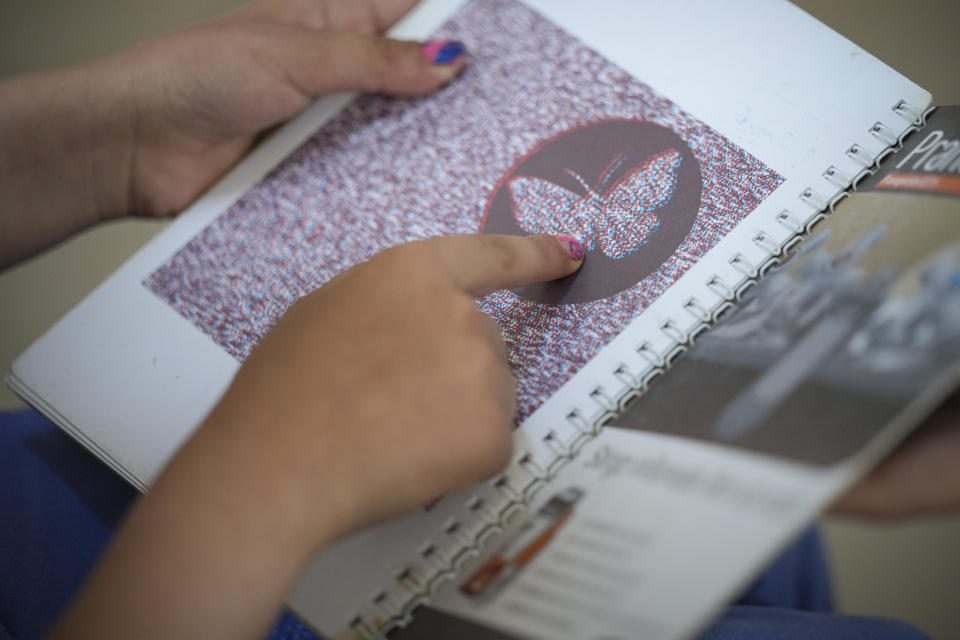 A child points at test shapes during an eyesight examination performed by volunteer ophthalmologists, in Nucsoara, Romania, Saturday, May 29, 2021. Dozens of disadvantaged young Romanian children got a chance to get their eyesight examined for the first time in their lives during an event arranged by humanitarian organization Casa Buna, or Good House, which has played a prominent role in supporting the local children's lives throughout the pandemic. (AP Photo/Vadim Ghirda)