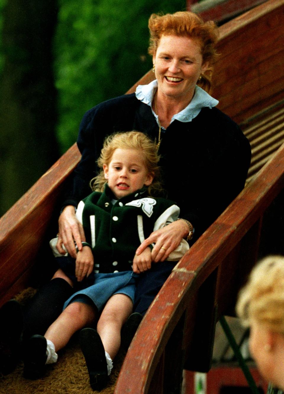 Sarah Ferguson and Princess Beatrice riding down a slide