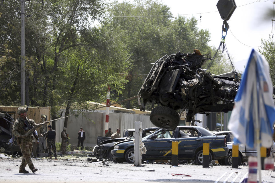 Resolute Support (RS) forces remove a damaged vehicle after a car bomb explosion in Kabul, Afghanistan, Thursday, Sept. 5, 2019. A car bomb rocked the Afghan capital on Thursday and smoke rose from a part of eastern Kabul near a neighborhood housing the U.S. Embassy, the NATO Resolute Support mission and other diplomatic missions. (AP Photo/Rahmat Gul)