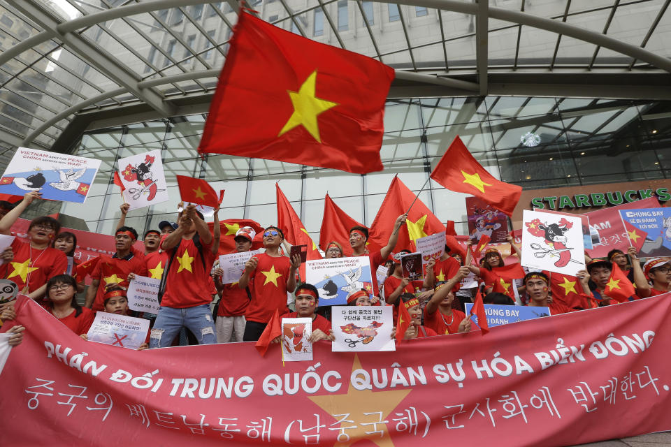 FILE - In this July 24, 2016, file photo, Vietnamese protesters hold their national flags, anti-China placards and a banner that reads: "We oppose China because they escalate tensions on the waters of the South China Sea" during a rally against China near the Chinese Embassy in Seoul. Vietnam's selection as the venue for the second summit between U.S. President Donald Trump and North Korean leader Kim Jong Un is largely a matter of convenience and security, but not without bigger stakes. Host Vietnam hopes to boost its international profile as diplomatic leverage against its big northern neighbor China, whose historical pushiness is manifested nowadays in its territorial claims in the South China Sea over waters claimed by Hanoi. (AP Photo/Ahn Young-joon, File)