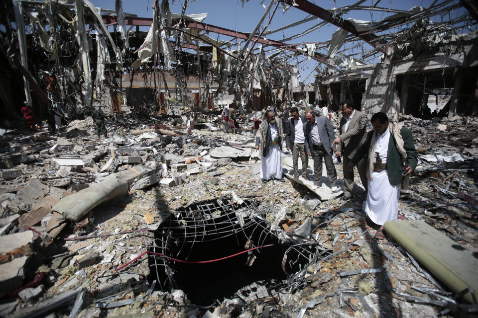 FILE - In this Oct. 13, 2016, file photo, members of the Higher Council for Civilian Community Organization inspect a destroyed funeral hall as they protest against a deadly Saudi-led airstrike on a funeral hall in Sanaa, Yemen. President Joe Biden's announcement that the U.S. will end its support of a Saudi-led coalition's years-long war against Yemen's Houthi rebels likely will increase pressure on the kingdom to end its campaign there, though reaching an enduring peace for the Arab world's poorest country still remains in question. (AP Photo/Hani Mohammed, File)